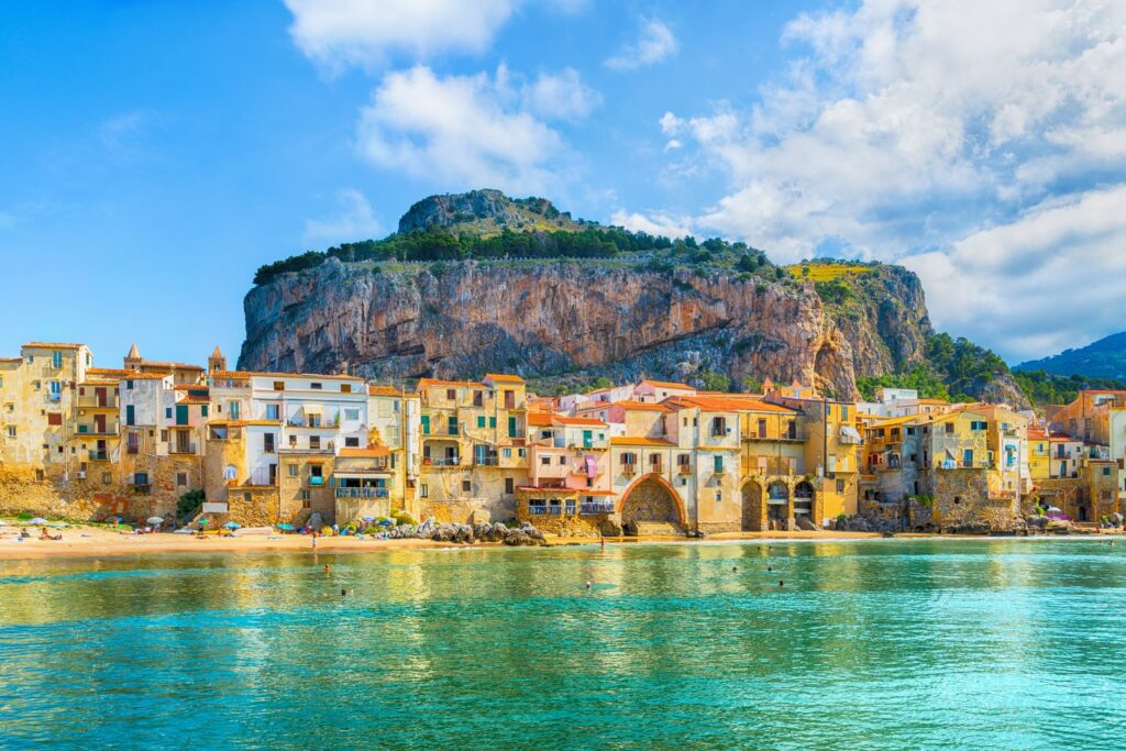 Cefalù łączy normańską katedrę, kolorowe kamienice nad morzem i piaszczystą plażę pod skałą La Rocca.