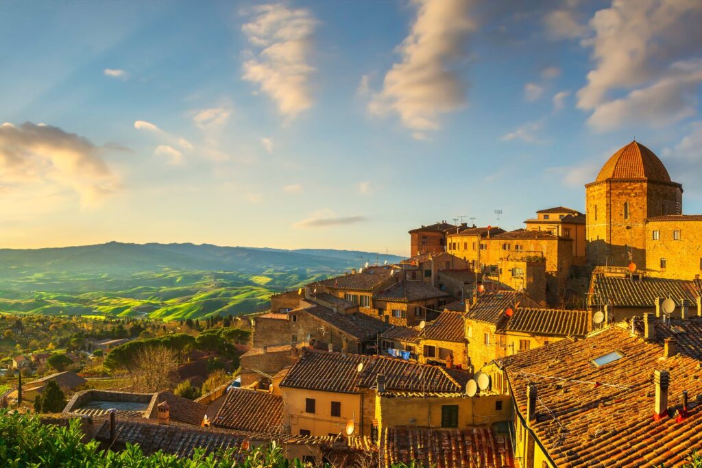 Volterra o zachodzie słońca odsłania panoramę na pofałdowane pola wokół etruskiego miasta.