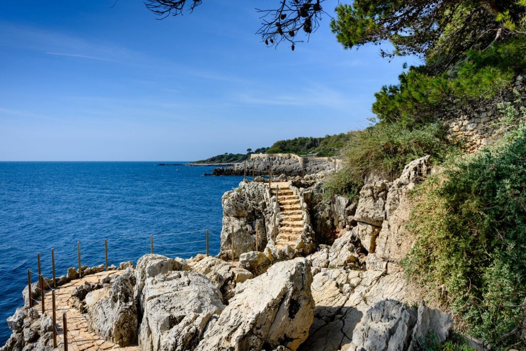 Sentier du Littoral prowadzi skalistym brzegiem Cap d'Antibes nad turkusową wodą